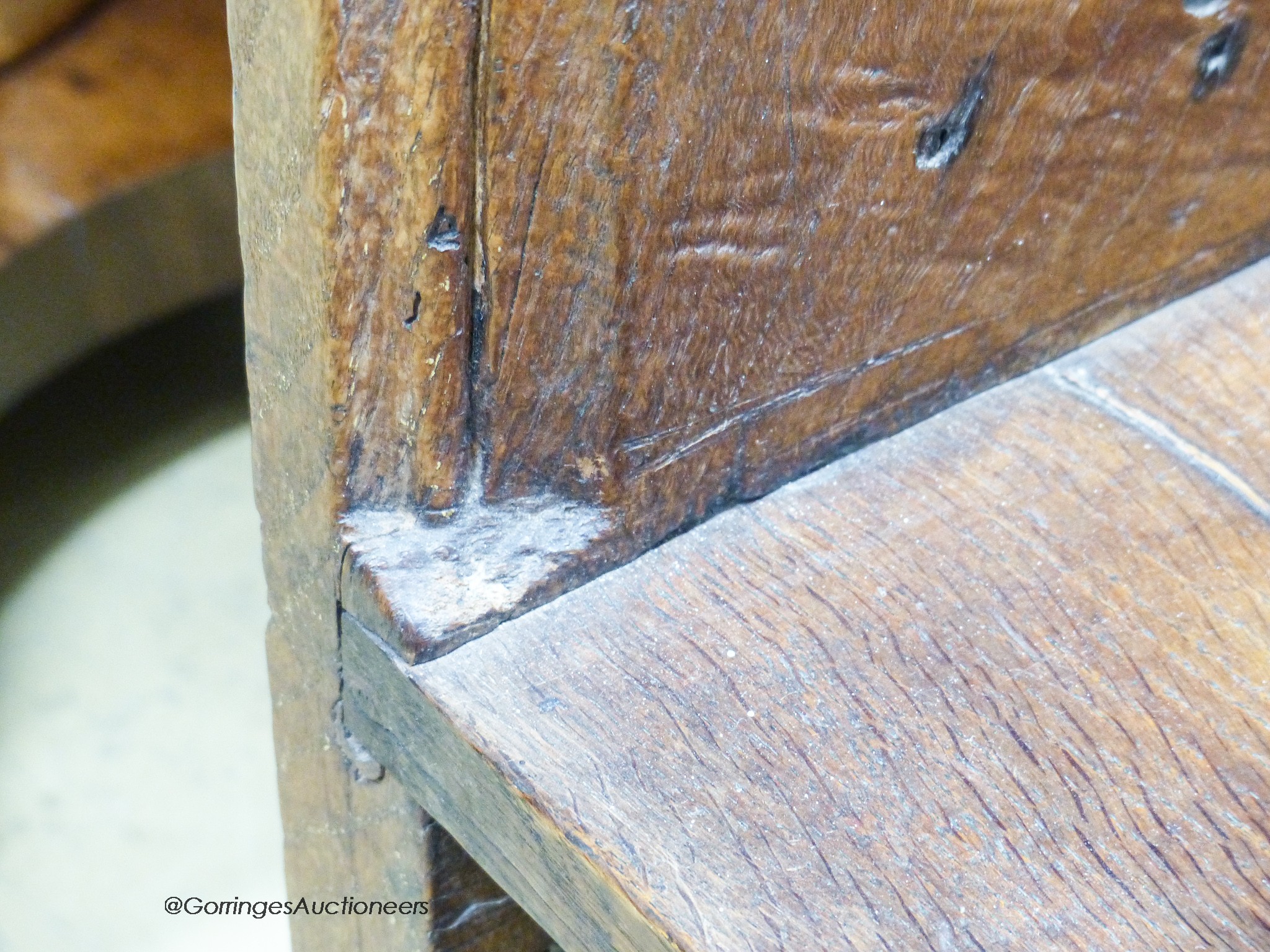 A pair of 15th century oak pew ends with stylised leaf and berry fleur-de-lys finials, joined by a later bench seat, length 85cm, depth 27cm, height 92cm